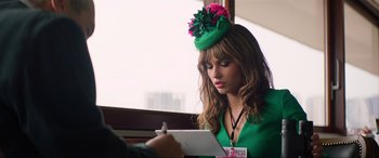 Movie still from “Charlie's Angels” (2019), directed by Elizabeth Banks – A woman wearing a green hat writing on a paper; Close Up shot, Over the shoulder angle