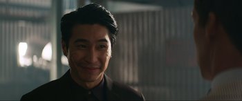 Movie still from “Charlie's Angels” (2019), directed by Elizabeth Banks – A person wearing a suit and smiling; Close Up shot, Over the shoulder angle