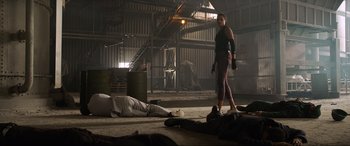 Movie still from “Charlie's Angels” (2019), directed by Elizabeth Banks – A woman standing next to a man laying on the ground; Wide shot, Low angle