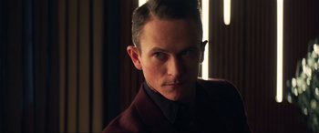 Movie still from “Charlie's Angels” (2019), directed by Elizabeth Banks – A person wearing a suit and tie; Close Up shot, Over the shoulder angle