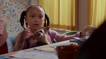 Movie still from “Cheaper by the Dozen” (2022), directed by Gail Lerner – A little girl with pigtails holding a small dog; Close Up shot, Over the shoulder angle