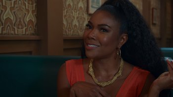 Movie still from “Cheaper by the Dozen” (2022), directed by Gail Lerner – A woman in a red dress is smiling; Close Up shot, Over the shoulder angle