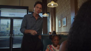 Movie still from “Cheaper by the Dozen” (2022), directed by Gail Lerner – A man standing next to a little girl in a restaurant; Medium shot, Over the shoulder angle
