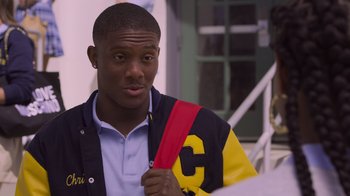 Movie still from “Cheaper by the Dozen” (2022), directed by Gail Lerner – A young man holding a red and yellow bag; Close Up shot, Over the shoulder angle
