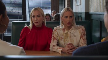 Movie still from “Cheaper by the Dozen” (2022), directed by Gail Lerner – Two women sitting at a table in front of each other; Close Up shot, Over the shoulder angle