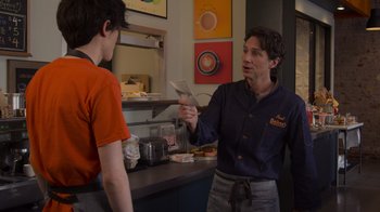 Movie still from “Cheaper by the Dozen” (2022), directed by Gail Lerner – A man is talking to a boy in a kitchen; Medium shot, Over the shoulder angle