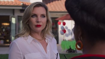 Movie still from “Cheaper by the Dozen” (2022), directed by Gail Lerner – A woman in a white shirt and red lipstick looking into the camera; Close Up shot, Over the shoulder angle
