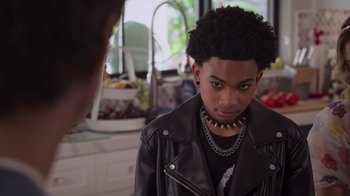 Movie still from “Cheaper by the Dozen” (2022), directed by Gail Lerner – A young man wearing a black leather jacket; Close Up shot, Over the shoulder angle