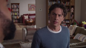 Movie still from “Cheaper by the Dozen” (2022), directed by Gail Lerner – A man standing in a living room with a couch in the background; Close Up shot, Over the shoulder angle