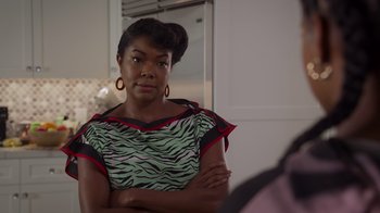 Movie still from “Cheaper by the Dozen” (2022), directed by Gail Lerner – A woman with her arms crossed looking at a mirror; Close Up shot, Over the shoulder angle