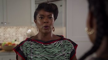 Movie still from “Cheaper by the Dozen” (2022), directed by Gail Lerner – A black woman with a green and black top; Close Up shot, Over the shoulder angle