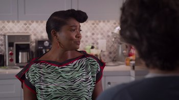 Movie still from “Cheaper by the Dozen” (2022), directed by Gail Lerner – A woman in a green and black dress talking to a man; Medium shot, Over the shoulder angle