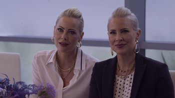 Movie still from “Cheaper by the Dozen” (2022), directed by Gail Lerner – A couple of women standing next to each other in front of a window; Close Up shot, Over the shoulder angle