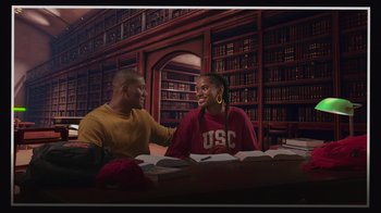 Movie still from “Cheaper by the Dozen” (2022), directed by Gail Lerner – A couple of people sitting at a table in a library; Medium shot, Low angle