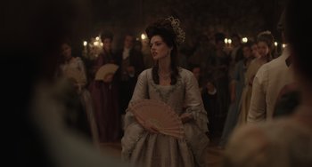 A woman dressed in period clothing holding a fan