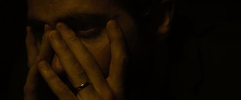 Movie still from “Enemy” (2013), directed by Denis Villeneuve – A person with their hands covering their face; Extreme Close Up shot, High angle