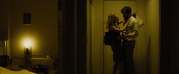 Movie still from “Enemy” (2013), directed by Denis Villeneuve – A man and a woman standing next to each other in a room; Medium shot, Low angle