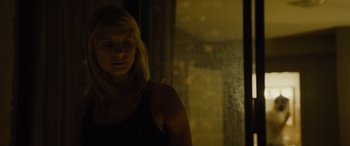 Movie still from “Enemy” (2013), directed by Denis Villeneuve – A woman standing next to a window in a dark room; Close Up shot, Low angle