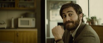 Movie still from “Enemy” (2013), directed by Denis Villeneuve – A person wearing a suit and tie; Close Up shot, Over the shoulder angle