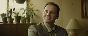 Movie still from “Enemy” (2013), directed by Denis Villeneuve – A person wearing a suit and tie; Close Up shot, Low angle