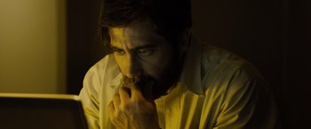Movie still from “Enemy” (2013), directed by Denis Villeneuve – A man in a white shirt eating a donut; Close Up shot, High angle