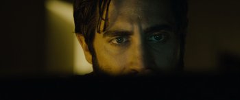 Movie still from “Enemy” (2013), directed by Denis Villeneuve – A man's face in the dark; Extreme Close Up shot, Over the shoulder angle