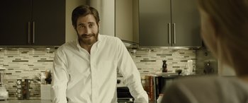Movie still from “Enemy” (2013), directed by Denis Villeneuve – A person in a kitchen; Medium shot, Over the shoulder angle