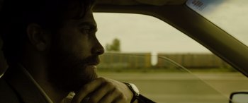 Movie still from “Enemy” (2013), directed by Denis Villeneuve – A person sitting in a car; Close Up shot, Over the shoulder angle