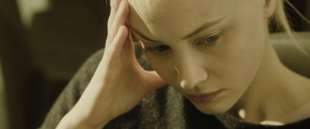Movie still from “Enemy” (2013), directed by Denis Villeneuve – A person with a hand on her head; Close Up shot, High angle