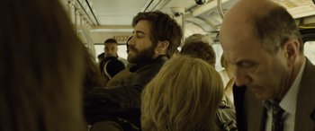 Movie still from “Enemy” (2013), directed by Denis Villeneuve – A man sitting on a public transit bus; Medium shot, Over the shoulder angle
