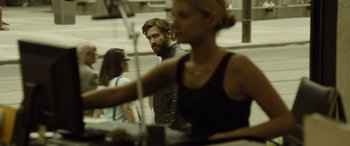 Movie still from “Enemy” (2013), directed by Denis Villeneuve – A man and a woman are standing in a room; Medium shot, Over the shoulder angle