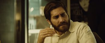 Movie still from “Enemy” (2013), directed by Denis Villeneuve – A person with a beard; Close Up shot, Over the shoulder angle