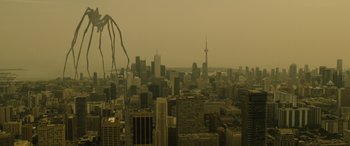 Movie still from “Enemy” (2013), directed by Denis Villeneuve – An aerial view of a large city with tall buildings; Extreme Wide shot, High angle