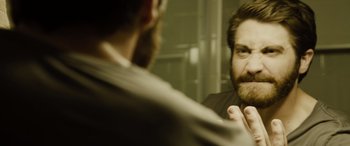 Movie still from “Enemy” (2013), directed by Denis Villeneuve – A man looking at himself in the mirror; Close Up shot, Over the shoulder angle