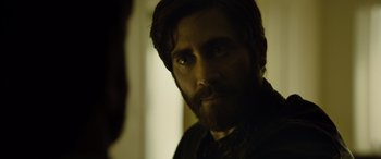 Movie still from “Enemy” (2013), directed by Denis Villeneuve – A person with a beard; Close Up shot, Over the shoulder angle