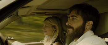 Movie still from “Enemy” (2013), directed by Denis Villeneuve – A man and a woman sitting in a car looking out the window; Close Up shot, Low angle