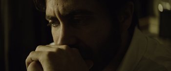 Movie still from “Enemy” (2013), directed by Denis Villeneuve – A man with his hand under his chin; Extreme Close Up shot, Low angle