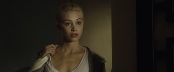 Movie still from “Enemy” (2013), directed by Denis Villeneuve – A beautiful young lady standing next to a wall; Close Up shot, Over the shoulder angle