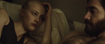 Movie still from “Enemy” (2013), directed by Denis Villeneuve – A woman laying in bed with her head resting on a pillow; Close Up shot, Overhead angle