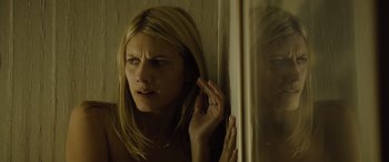 Movie still from “Enemy” (2013), directed by Denis Villeneuve – A woman with her hand to her ear looking out of a window; Close Up shot, Low angle