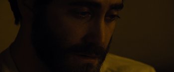 Movie still from “Enemy” (2013), directed by Denis Villeneuve – A person's face in the dark; Extreme Close Up shot, High angle