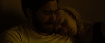 Movie still from “Enemy” (2013), directed by Denis Villeneuve – A man and a woman snuggling in a dark room; Close Up shot, Overhead angle