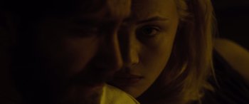 Movie still from “Enemy” (2013), directed by Denis Villeneuve – A woman's face in a dark room; Extreme Close Up shot, Over the shoulder angle