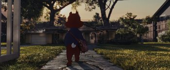 Movie still from “Chip 'n Dale: Rescue Rangers” (2022), directed by Akiva Schaffer – A teddy bear is standing on a path in front of a house; Wide shot, High angle