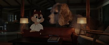 Movie still from “Chip 'n Dale: Rescue Rangers” (2022), directed by Akiva Schaffer – A dog and a squirrel are sitting on a couch; Medium shot, High angle