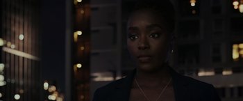 Movie still from “Chip 'n Dale: Rescue Rangers” (2022), directed by Akiva Schaffer – A woman with a necklace is standing in a dark room; Close Up shot, Over the shoulder angle