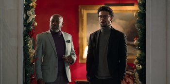 Two men standing next to each other in front of a painting