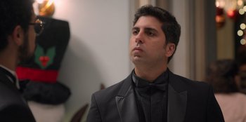 Movie still from “Christmas Full of Grace” (2022), directed by Pedro Antônio Paes – A person wearing a suit and bow tie; Close Up shot, Low angle