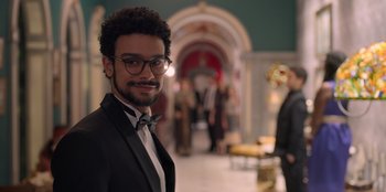 A man in a suit and bow tie smiling for the camera