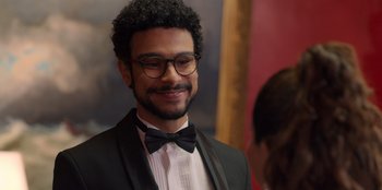 A man in a suit and bow tie smiling